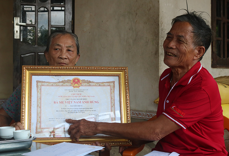 Ông Trần Quang Duy cho phóng viên xem Bằng danh hiệu Bà mẹ VNAH mà Đảng, Nhà nước truy tặng cho bà Nguyễn Thị Vụ.