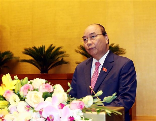 Thủ tướng Nguyễn Xuân Phúc đọc báo cáo của Chính phủ. (Ảnh: Trọng Đức/TTXVN)