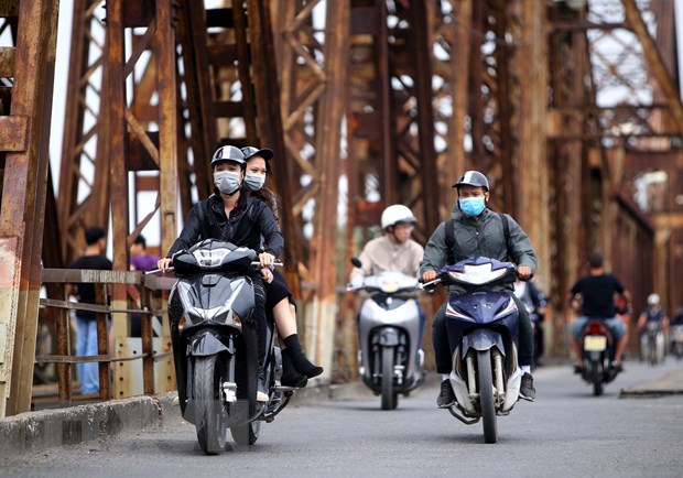 Người dân với trang phục áo ấm đi trên cầu Long Biên (Hà Nội). (Ảnh: Danh Lam/TTXVN)