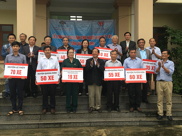 Đại diện lãnh đạo các sở, ban, nghành trao tượng trưng xe lăn cho các huyện.