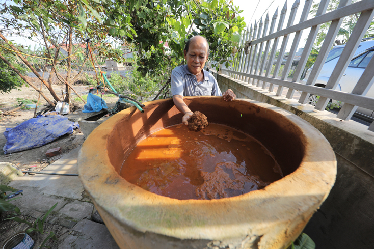 Bác Chu Văn Thái, một người dân Quảng Kim, 73 tuổi, bên giếng nước nhiễm phèn nặng.