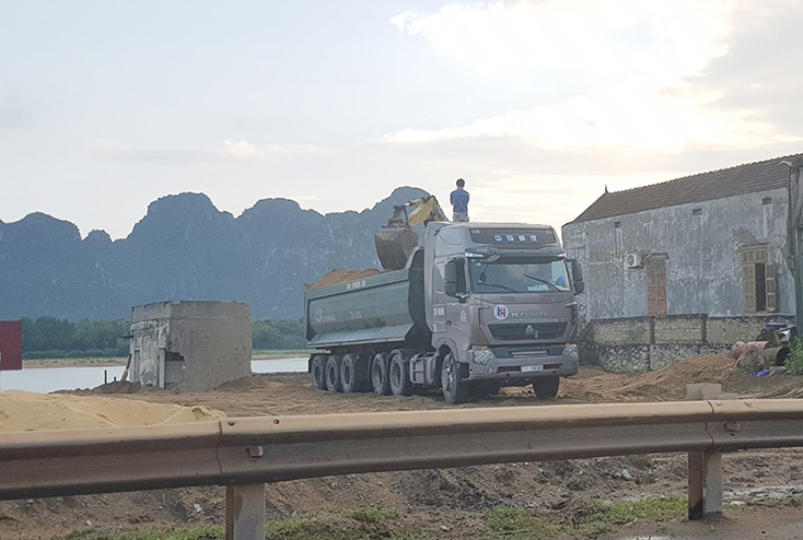  Xe ô tô vận tải cỡ lớn vào lấy cát từ một bãi tập kết cát trái phép.