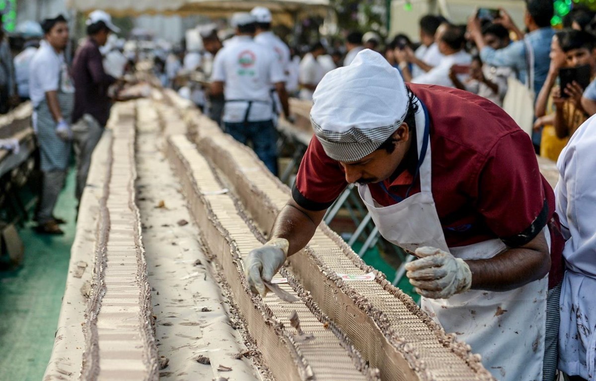 Một thợ làm bánh làm việc trên một chiếc bánh dài gần 6,5km ở bang Kerala miền nam Ấn Độ ngày 15/1. (Ảnh: AFP)
