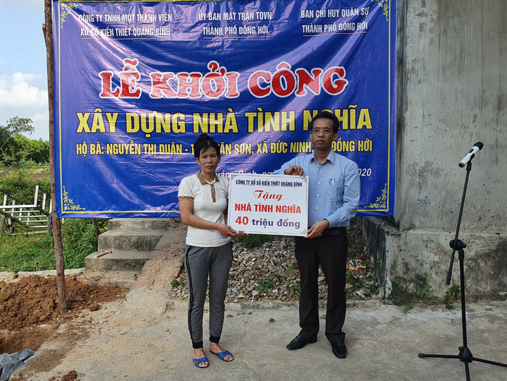 Đại diện Công ty TNHH MTV Xổ số kiến thiết Quảng Bình trao biển tượng trưng hỗ trợ làm nhà cho chị Duân
