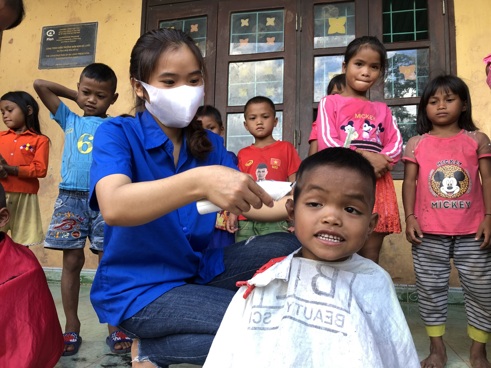 Các tình nguyện viên căt tóc cho các em.