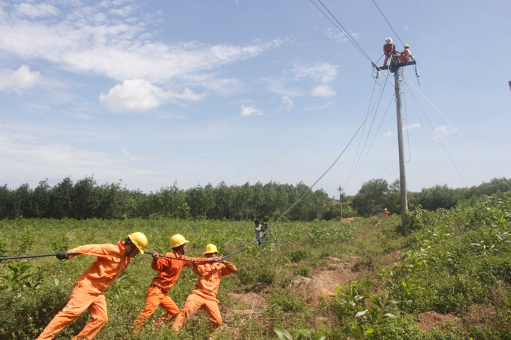 Công nhân Điện lực Lệ Thủy thi công nâng cấp hệ thống lưới điện.