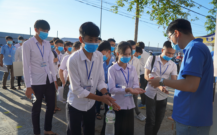 Hỗ trợ thí sinh sát khuẩn tay trước khi vào trường thi.