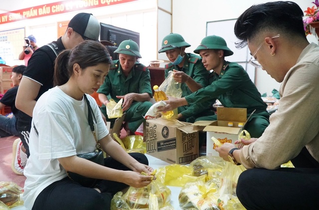 Các tình nguyện viên cùng các chiến sĩ chuẩn bị quà để trao cho các em nhỏ.