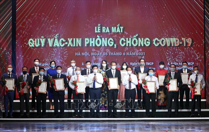 Đại diện các tập đoàn, tổng công ty, doanh nghiệp trao ủng hộ Qũy vaccine phòng COVID-19. Ảnh: Dương Giang/TTXVN