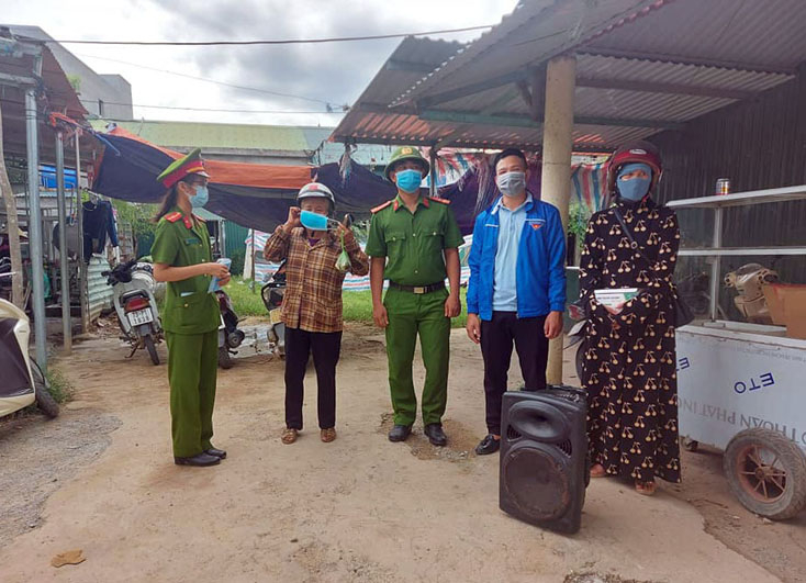 Lực lượng chức năng tuyên truyền công tác phòng dịch Covid-19 và nhắc nhở người dân đeo khẩu trang khi ra đường