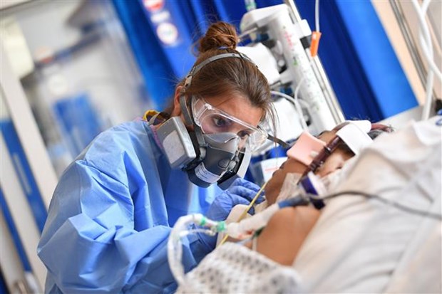 Nhân viên y tế điều trị cho bệnh nhân COVID-19 tại bệnh viện ở Cambridge (Anh). (Ảnh: AFP/ TTXVN)