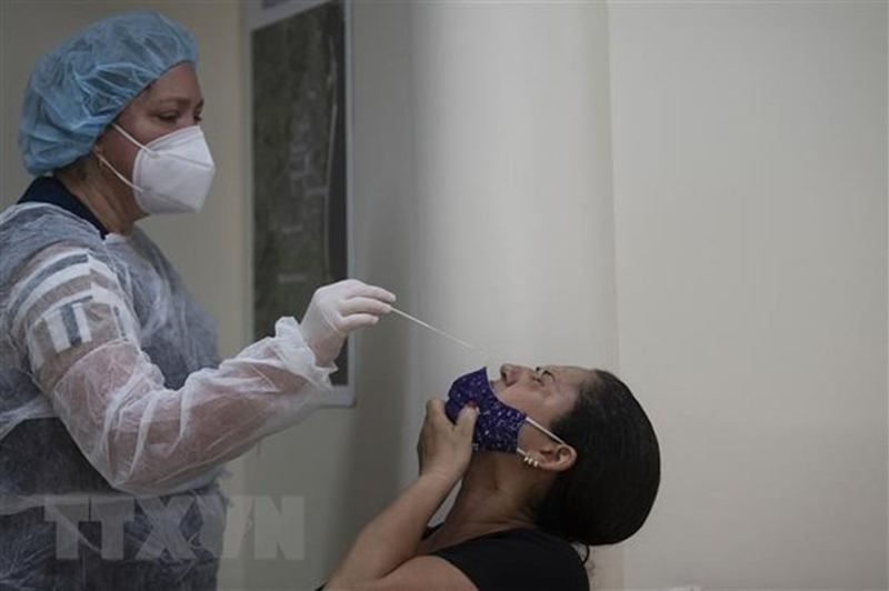 Nhân viên y tế lấy mẫu xét nghiệm COVID-19 cho người dân tại Rio de Janeiro ngày 5/1/2022. (Ảnh: AFP/TTXVN)