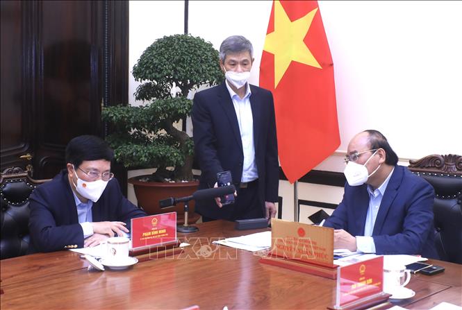 Chủ tịch nước Nguyễn Xuân Phúc nghe Đại sứ Việt Nam tại Ukraine Nguyễn Hồng Thạch báo cáo qua điện thoại về công tác bảo hộ công dân. Ảnh: Lâm Khánh/TTXVN