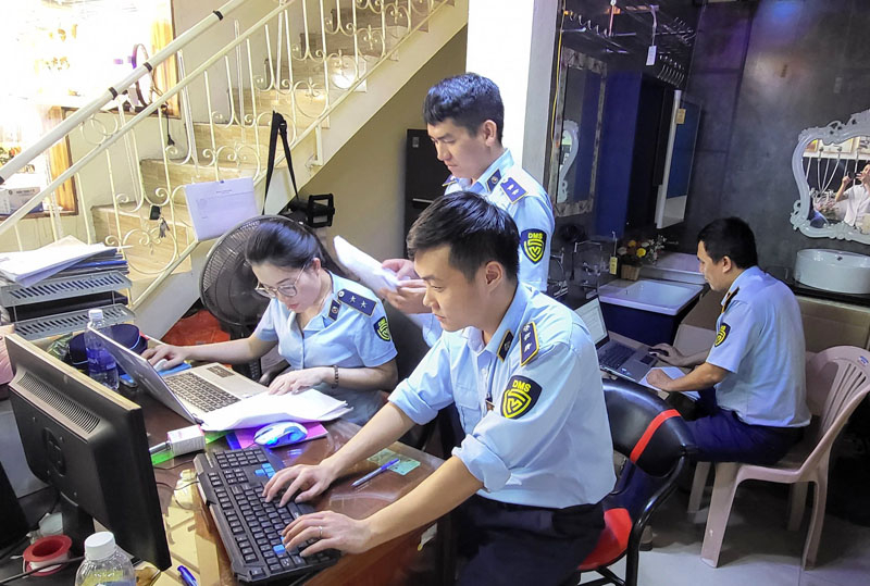 Lực lượng QLTT kiểm tra hàng hóa vi phạm và lập hồ sơ vụ việc.