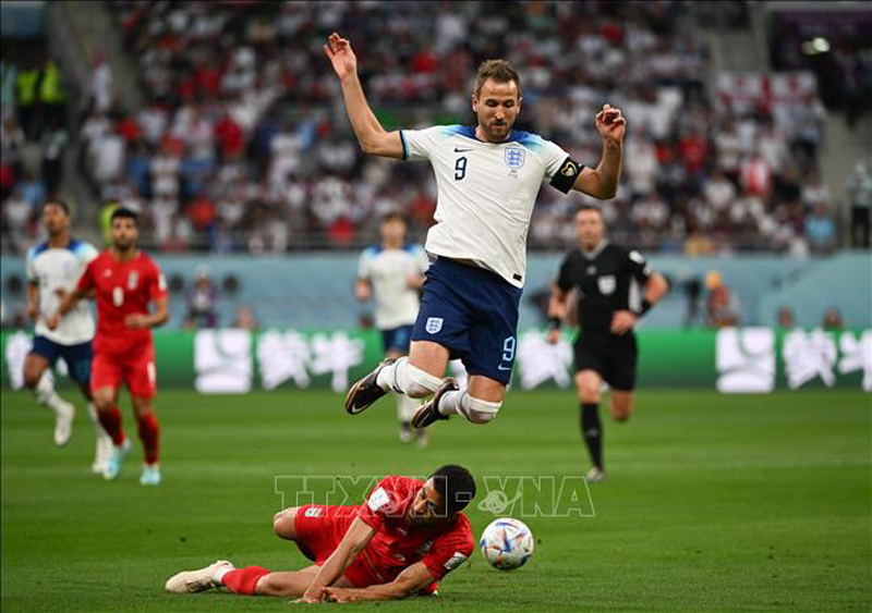 Pha vào bóng quyết liệt của hậu vệ Iran để ngăn cản đường lên bóng của Harry Kane, đội tuyển Anh. Ảnh: THX/TTXVN