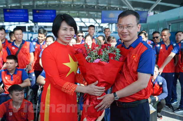 Phó Tổng cục trưởng Tổng cục Thể dục Thể thao Lê Thị Hoàng Yến (trái) trao tặng đóa hoa cổ vũ tinh thần cho Trưởng đoàn Nguyễn Hồng Minh. (Ảnh: Việt Anh/Vietnam+)