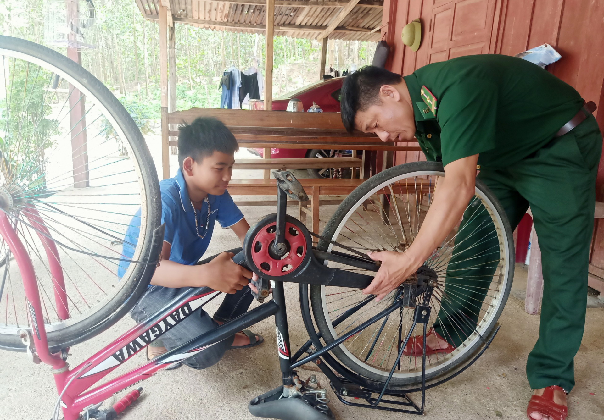 Thiếu tá Cao Văn Chính sửa chữa, bảo dưỡng xe đạp cho 2 