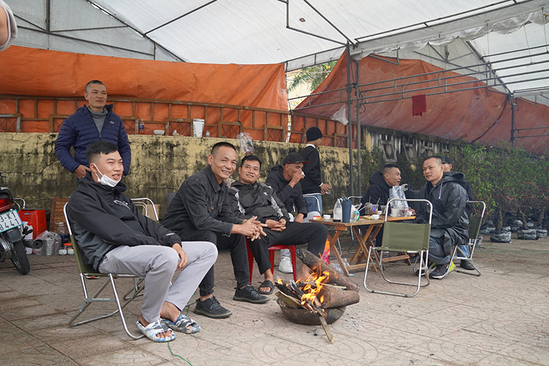 Vắng khách, những người bán hoa, cây cảnh tập trung đốt lửa sưởi ấm.