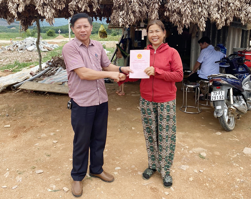 Lãnh đạo UBND xã Phú Định (Bố Trạch) trao giấy chứng nhận quyền sử dụng đất cho hộ tái định cư.