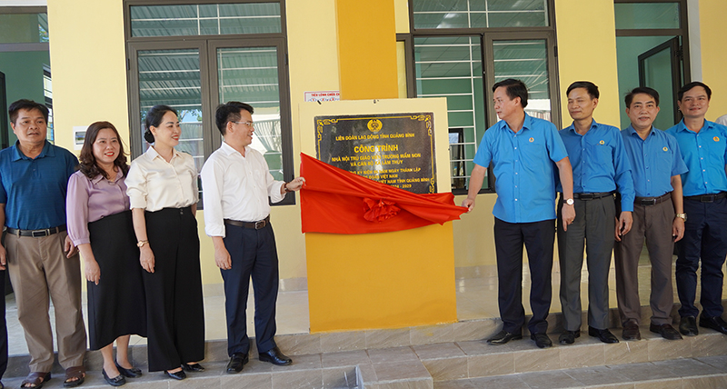 Các đại biểu kéo băng khánh thành công trình nhà nội trú giáo viên Trường mầm non và cán bộ xã Lâm Thủy (Lệ Thủy).