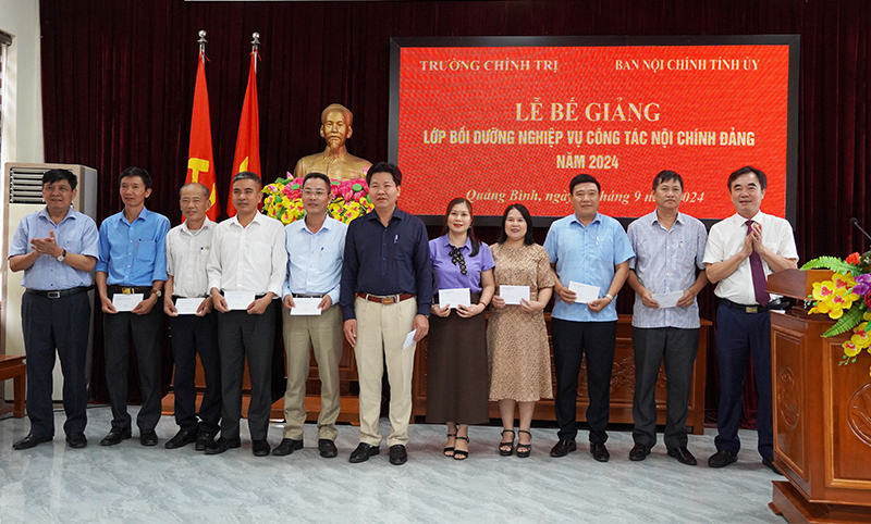 Đồng chí Trưởng ban Nội chính Tỉnh ủy Nguyễn Lương Bình và đồng chí Hiệu trưởng Trường Chính trị tỉnh Lê Công Toán trao thưởng cho các học viên có thành tích xuất sắc.