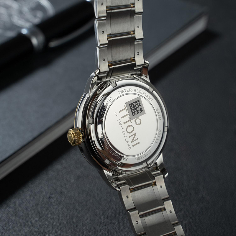 Chữ Swiss Made kết hợp cọc số giống Kim tự tháp, và hiệu ứng chải tia Sunburst màu vàng tạo nên khung cảnh rực rỡ đầy uy tín.