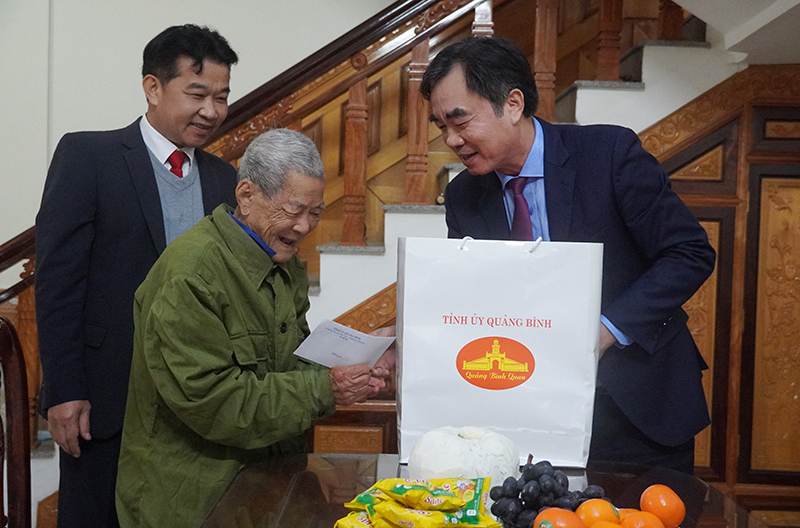 Đồng chí Trưởng Ban Nội chính Tỉnh ủy tặng quà, động viên đồng chí Đinh Xuân Phẩm, đảng viên 75 tuổi Đảng, tại thị trấn Quy Đạt.