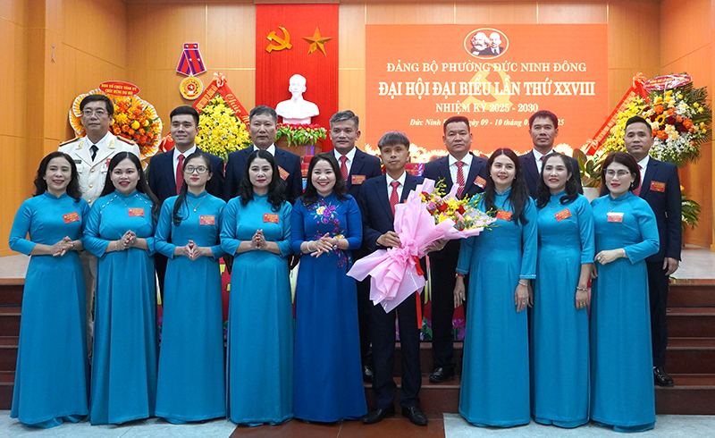 Đại diện lãnh đạo TP. Đồng Hới tặng hoa chúc mừng Ban Chấp hành Đảng bộ phường Đức Ninh Đông nhiệm kỳ 2025-2030.