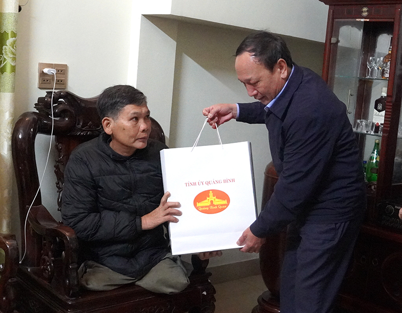 Đồng chí Phó Bí thư Thường trực Tỉnh ủy Trần Hải Châu tặng quà động viên thương binh Phùng Đình Thi.