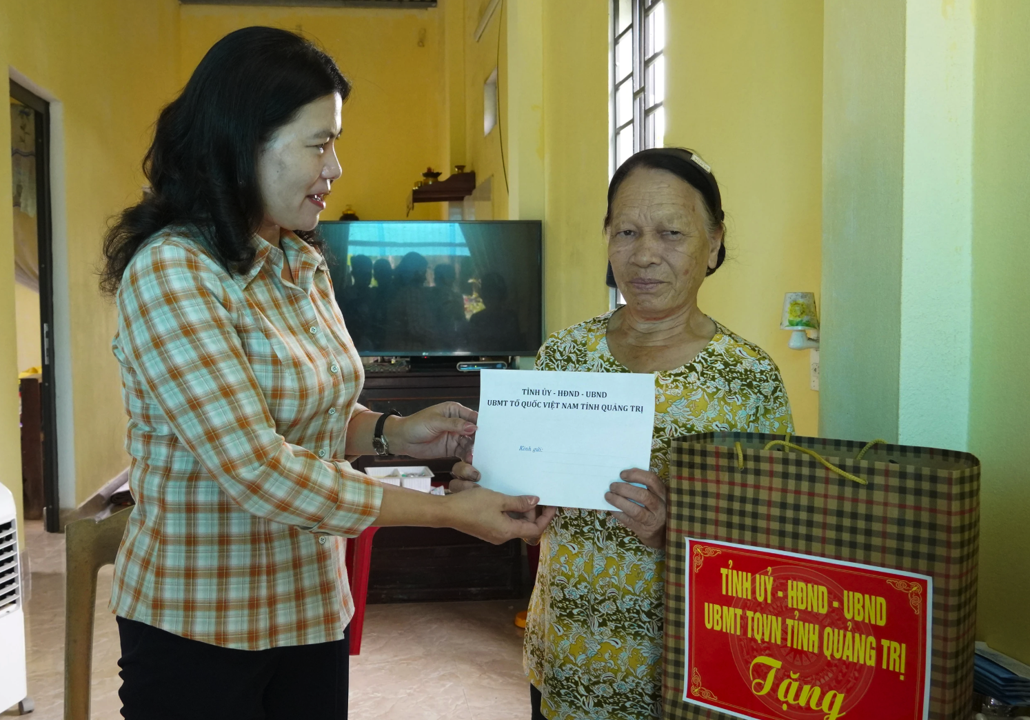 Trưởng ban Nội chính Tỉnh ủy Ly Kiều Vân tặng quà cho thương binh Lâm Thị Liên - Ảnh: N.H