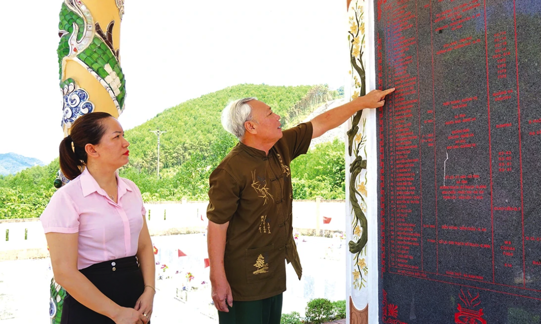 Ông Lương Thanh Phúc dò tìm tên liệt sĩ được khắc lên tấm bia ở đài tưởng niệm - Ảnh: T.T