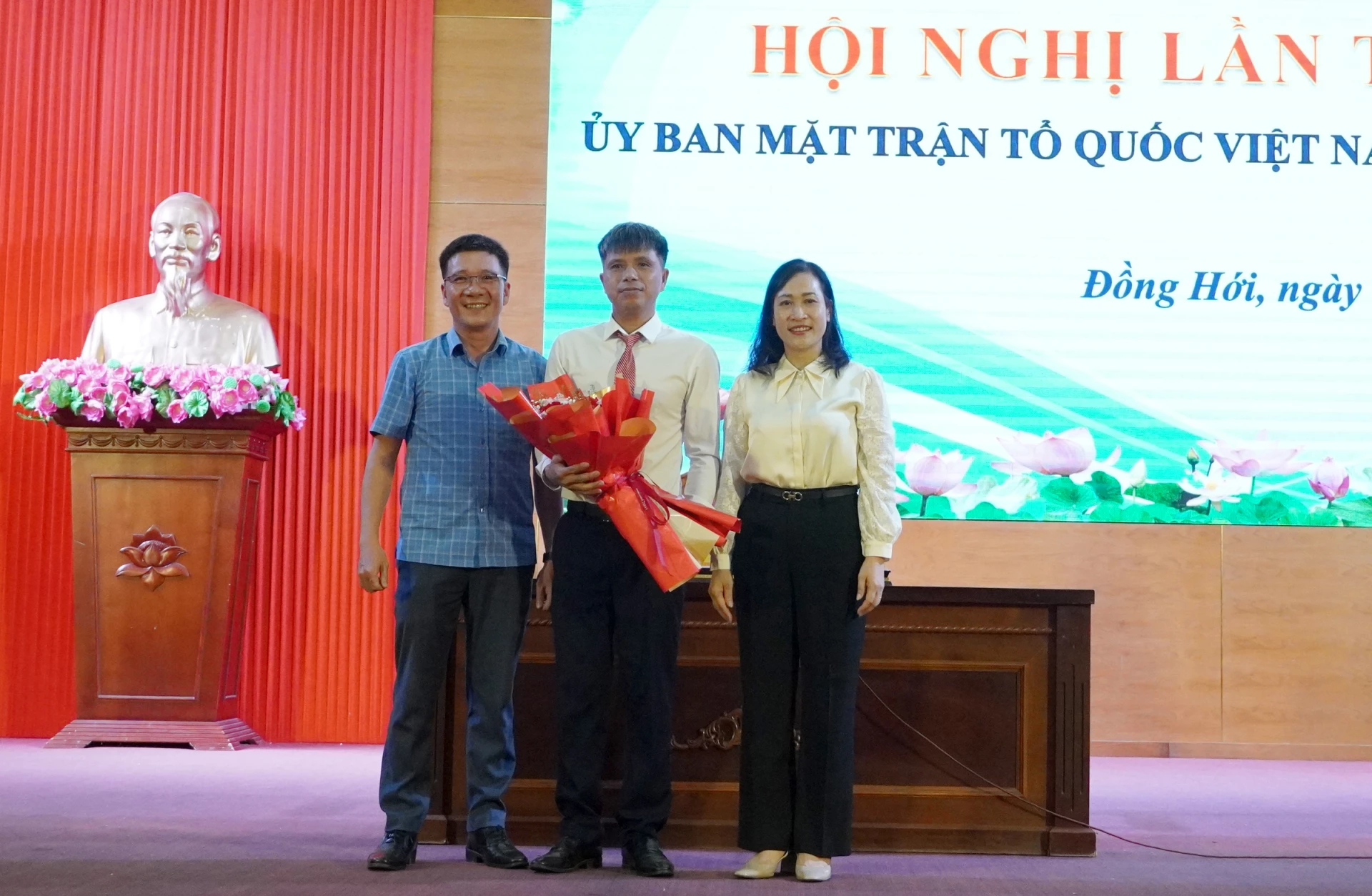 Đại diện lãnh đạo Đảng ủy phường Đồng Hới và Ủy ban MTTQVN tỉnh tặng hoa cho chúc mừng ông Bùi Quang Vinh. Ảnh: HT