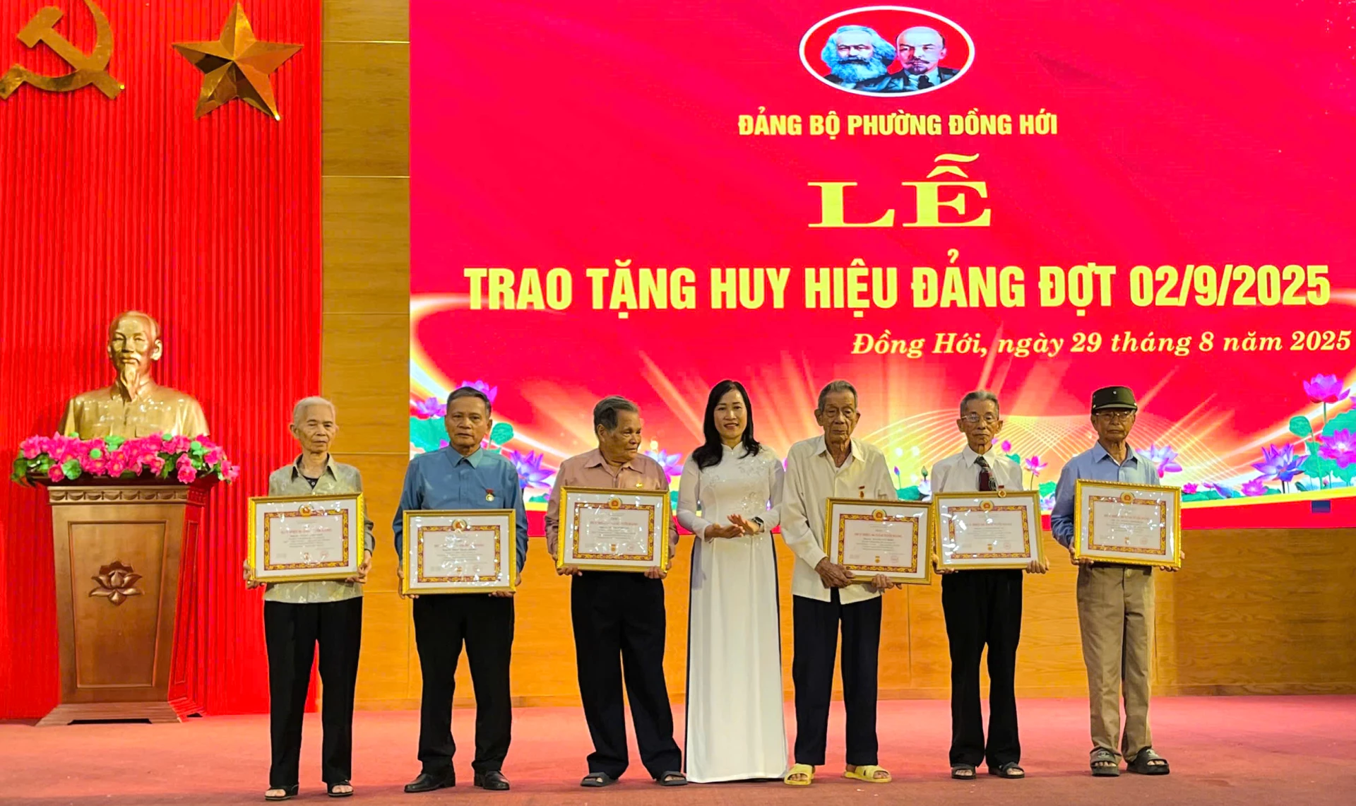 Đại diện Thường trực Đảng ủy phường Đồng Hới trao Huy hiệu Đảng cho các đảng viên lão thành. Ảnh: H.Tr.