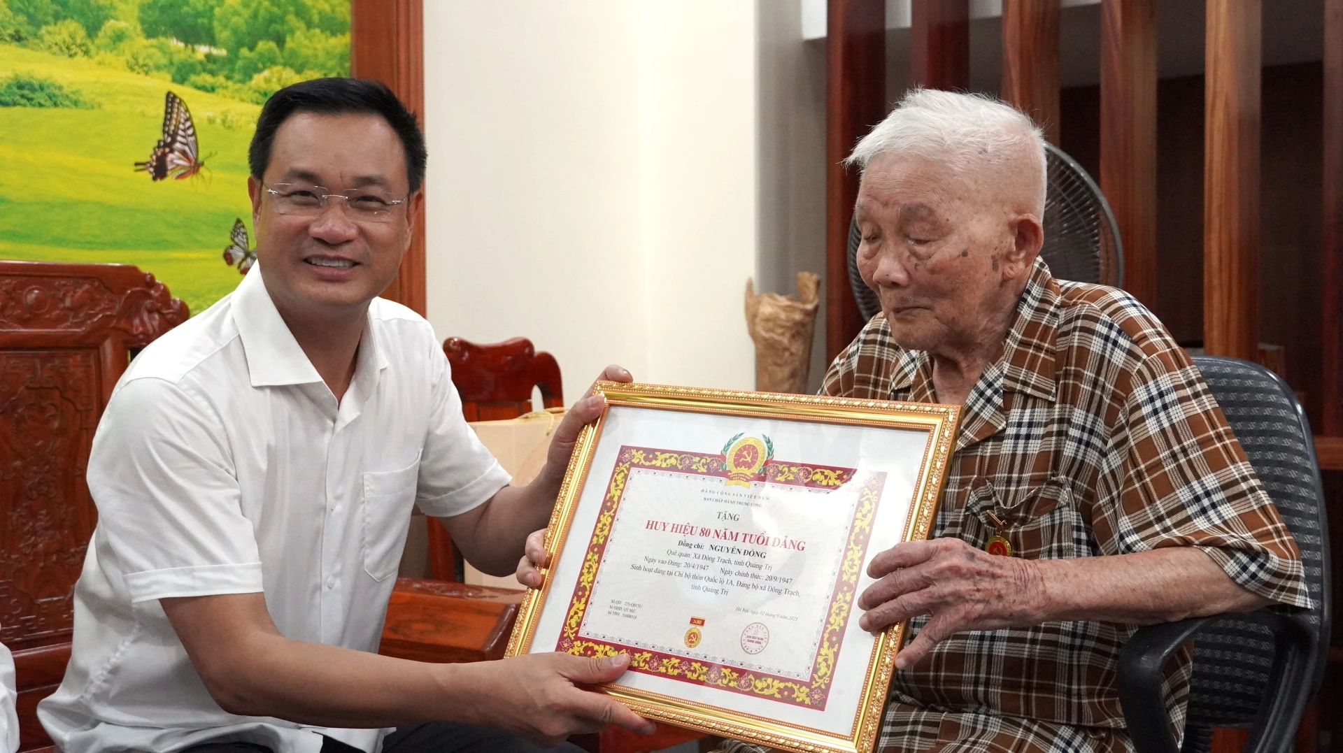 Bí thư Tỉnh ủy Lê Ngọc Quang trao tặng Huy hiệu 80 năm tuổi Đảng cho ông Nguyễn Đổng - Ảnh: QV