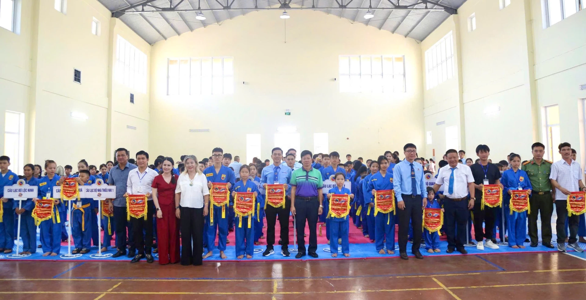 Phó Chủ tịch Liên đoàn Vovinam Việt Nam Nguyễn Tấn Nghĩa và Ban tổ chức giải tặng cờ lưu niệm cho các CLB và trọng tài - Ảnh: M.Đ