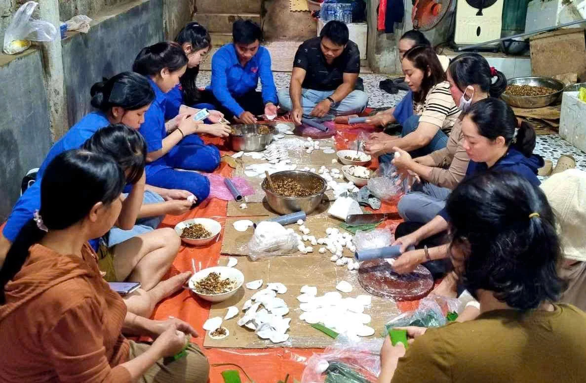 Thành viên Hội Thiện nguyện Tân Lập và tình nguyện viên gói bánh gây quỹ giúp người dân gặp khó khăn  -Ảnh: T.L