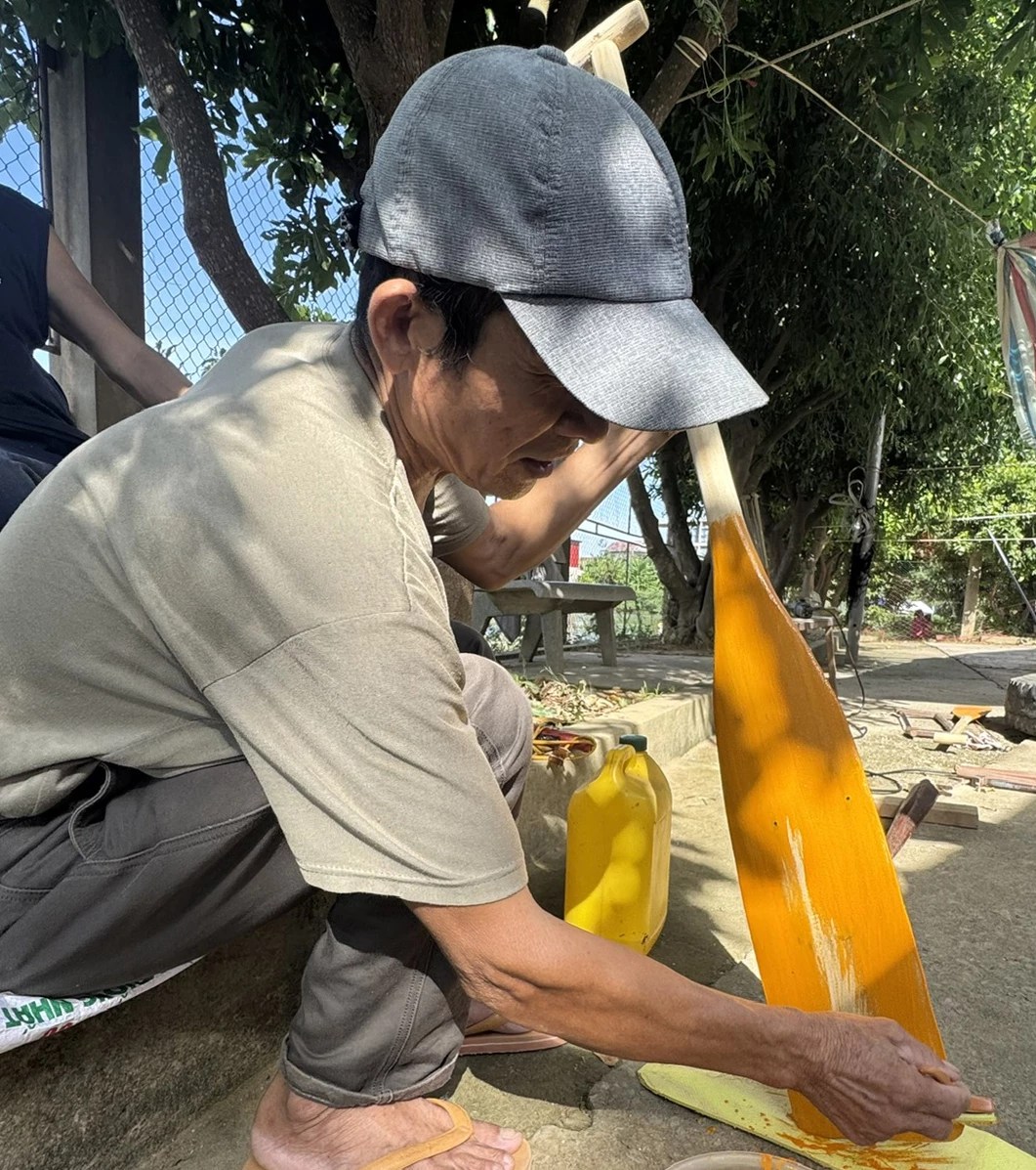 Ông Trần Việt Bắc sơn sửa lại mái chầm cho các trai bơi của làng An Xá - Ảnh: Ngọc Hải