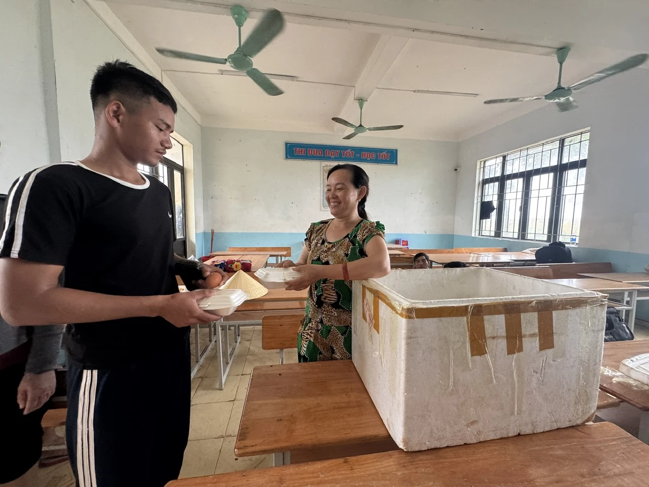 Người dân xã Phú Trạch hỗ trợ cơm cho công nhân tránh trú bão số 5 - Ảnh: N.H
