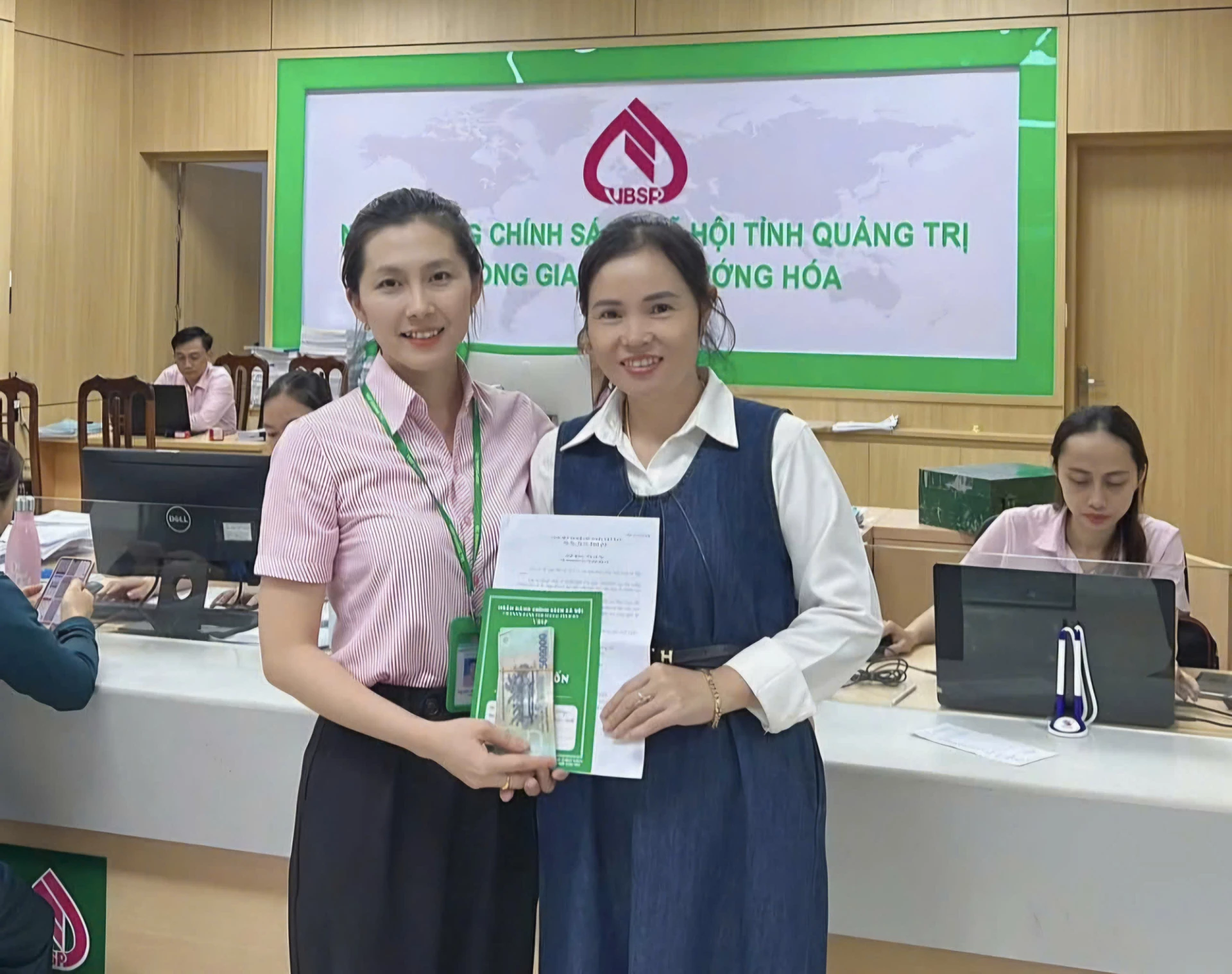 Cán bộ tín dụng NHCSXH Hướng Hoá trao số tiền giải ngân khoản vay cho khách hàng - Ảnh: M.L