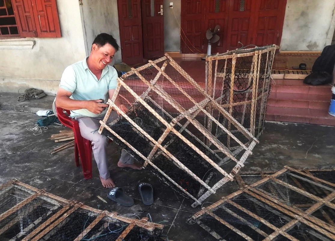 Ngư dân Hồ Sỹ Dưỡng sửa chữa lừ mực lá bị hư hỏng sau chuyến biển - Ảnh: S.H