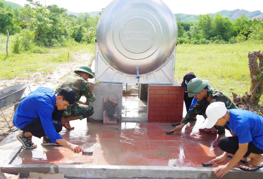 Các đoàn viên, thanh niên Đoàn xã Hiếu Giang cùng chiến sĩ Trung đoàn 19 xây dựng công trình nước sạch tại bản Chùa - Ảnh: L.M