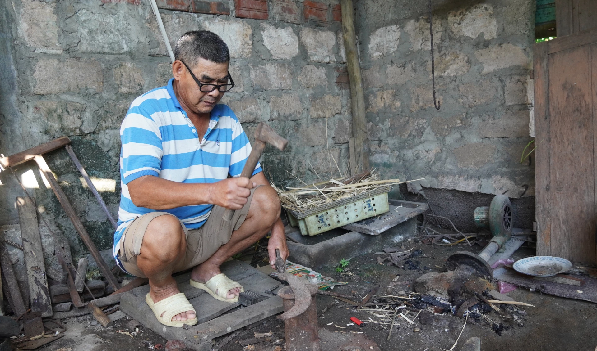Những lúc nhớ nghề, ông Lê Phước Dào lại tìm về với góc nhà quen thuộc, nơi có bể lò rèn,có chiếc đe, chiếc búa một thời gắn bó- Ảnh: M.N