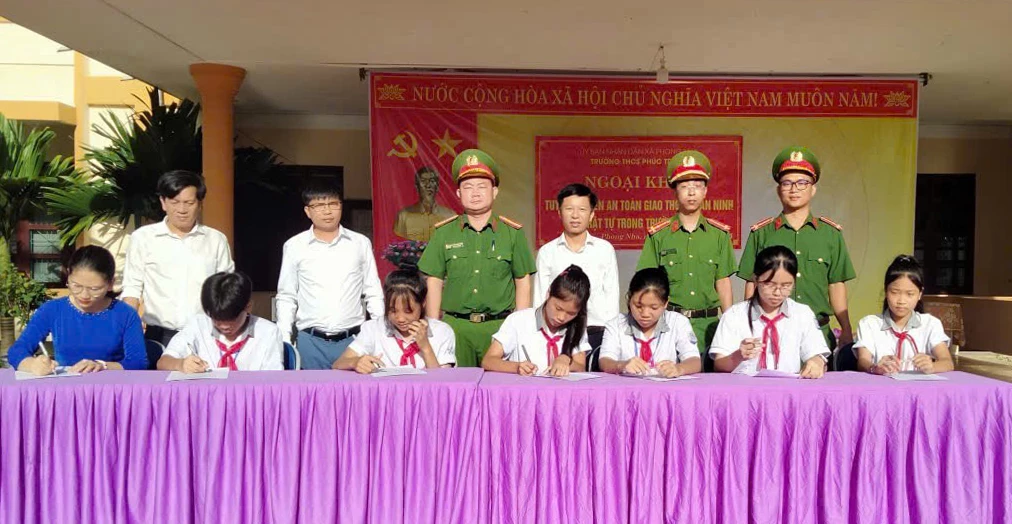 Lực lượng công an phối hợp các trường học tổ chức cho học sinh ký cam kết chấp hành pháp luật về trật tự, an toàn giao thông  - Ảnh: T.L